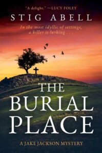 Cover of The Burial Place shows a windblown tree on a hill with a stone wal and cross, with black birds flying up against a red sky.