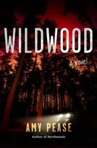 Cover of Wildwood shows lights of a car driving through deep woods under a dark sky that's tinted red.