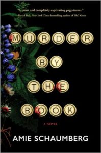 Cover of Murder by the Book shows old-fashioned typewriter keys spelling out the title with a bouquet of flowers beside them against a black background.
