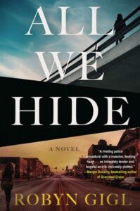 Cover of All We Hide shows a woman on a bridge intersecting a photo of a Midwestern main street. 