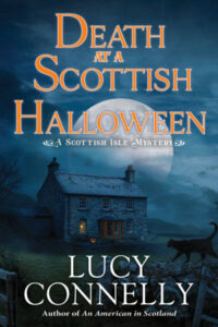 Cover of Death at a Scottish Halloween shows a stone croft at night with a light in the window, with a black cat in the foreground and a full moon rising behind the croft. 
