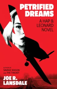 Cover of Petrified Dreams shows a woman's face superimposed against the silhouette of a small airplane with it's nose down toward a rural road through fields, all against a red background. 